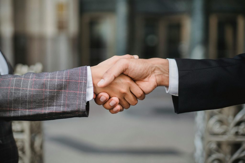 Un primer plano de dos empresarios dándose la mano, simbolizando cooperación y asociación.